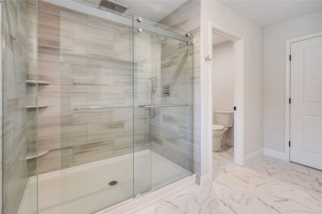 Bathroom with marble finish floor, a sink, double vanity, and baseboards | Image 24
