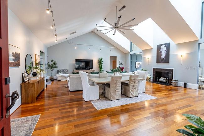 Step through the front door into a radiant great room where natural light pours through oversized skylights, highlighting the high ceilings, dining area and Brazilian wood flooring. | Image 17