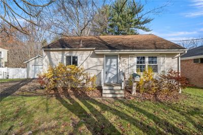 View of front facade with a front lawn and a garage | Image 1