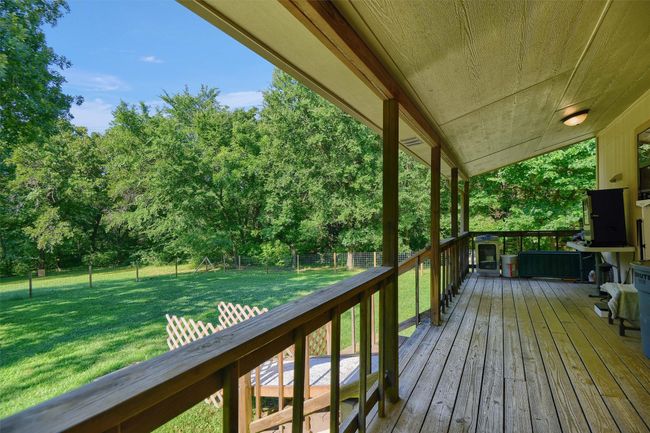 Wooden deck featuring a fenced backyard, a lawn, and a playground | Image 25