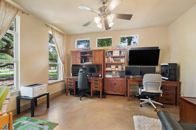 Office space with light tile patterned floors, ceiling fan, and baseboards | Image 26