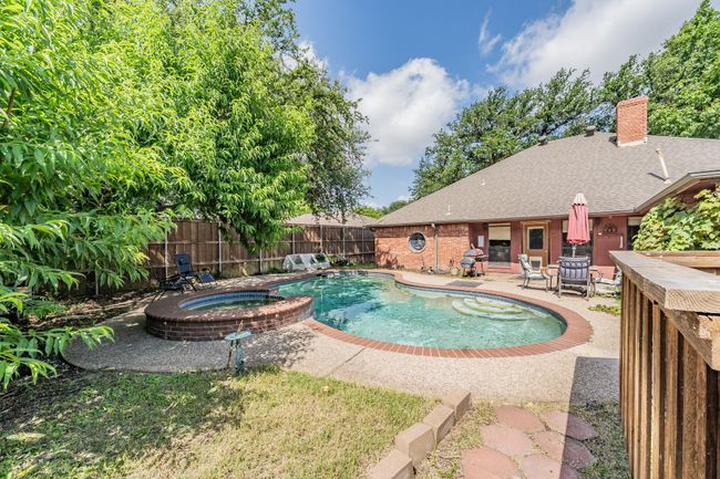 View of pool with a patio area and a pool with connected hot tub | Image 21