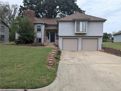 Raised ranch featuring a garage and a front lawn | Image 1