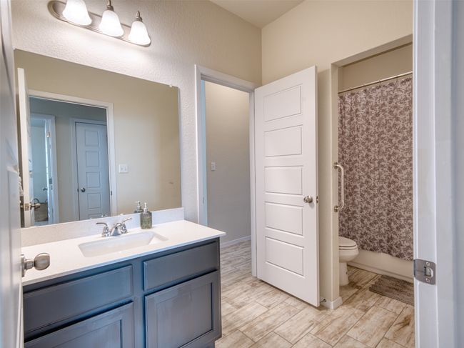Bathroom with vanity, toilet, and curtained shower | Image 17