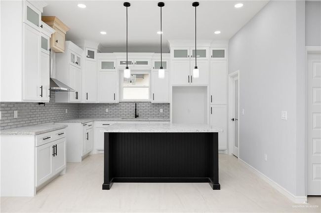 Kitchen featuring decorative backsplash, a center island, wall chimney range hood, pendant lighting, and recessed lighting | Image 6