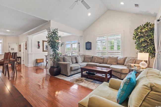 Living area with ceiling fan, wood-type flooring, a wainscoted wall, decorative columns, and recessed lighting | Image 29