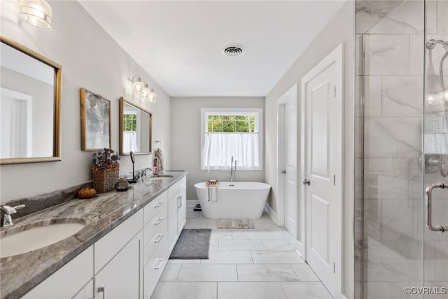 Bathroom with a sink, marble finish floor, a freestanding tub, visible vents, and a stall shower | Image 31