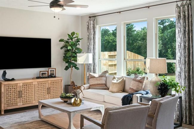 This light and bright spacious family room is the perfect layout for entertaining or just relaxing. Whether it's simply a night in or entertaining family and friends, this home has ample open space for everyone to enjoy! Featuring vinyl plank flooring, large windows, high ceilings, recessed lighting, and ceiling fan. | Image 4