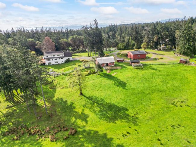 Aerial view of property and surrounding area featuring a heavily wooded area | Image 56