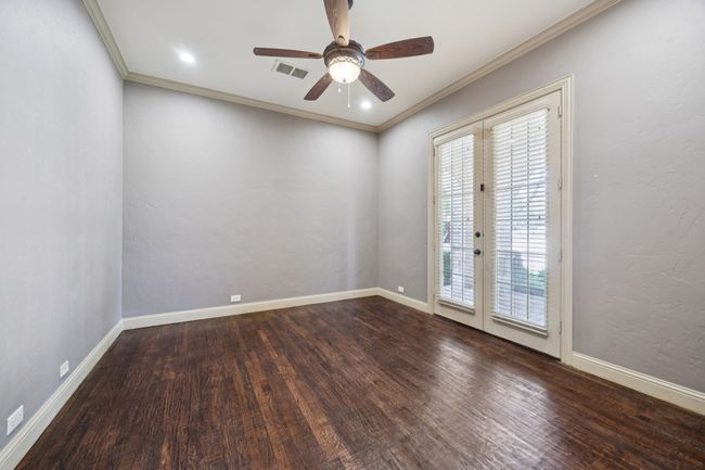 Empty room with plenty of natural light, ceiling fan, wood finished floors, crown molding, and baseboards | Image 9