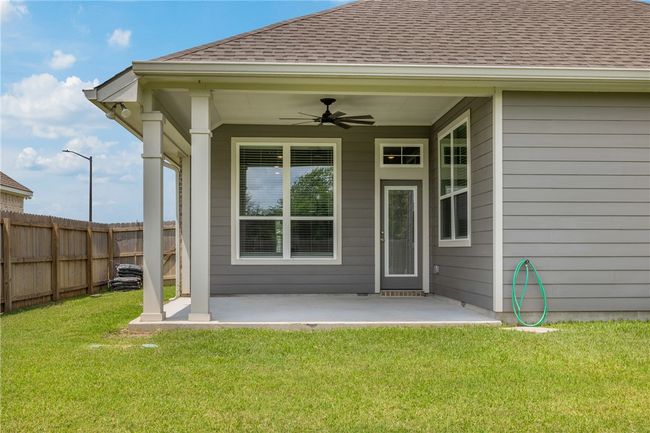 Entrance to property featuring roof with shingles, ceiling fan, and a patio | Image 5