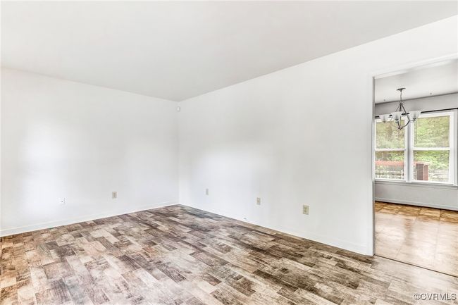 Spare room featuring wood finished floors and a chandelier | Image 8