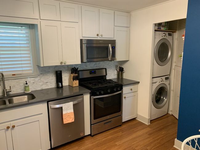 Kitchen featuring stacked washer and clothes dryer, dark countertops, and appliances with stainless steel finishes. | Image 8
