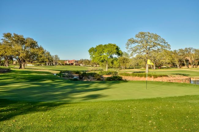Surrounding community with golf course view, a lawn, and a putting area | Image 34