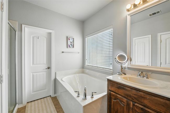 Full bath featuring vanity, a bath, a stall shower, and tile patterned floors | Image 32