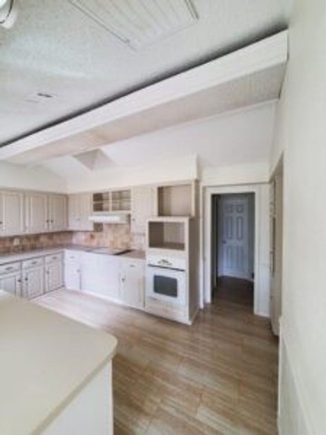 Kitchen with white appliances, light wood-style floors, and backsplash | Image 15