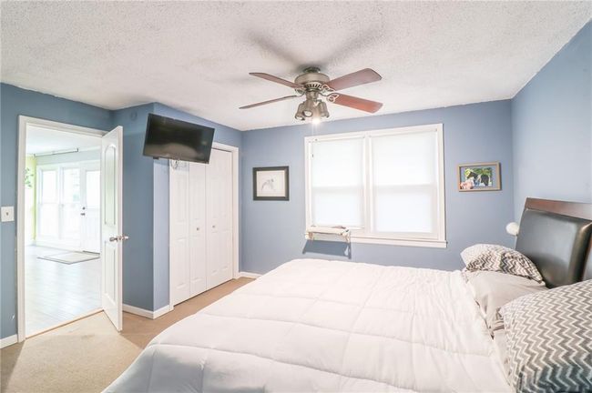 Bedroom featuring carpet, a textured ceiling, a ceiling fan, and a closet | Image 26