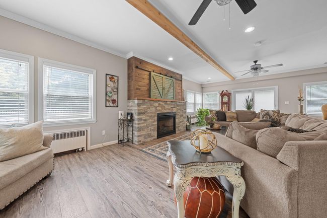 Living area with a chandelier, plenty of natural light, crown molding, and an office area | Image 9