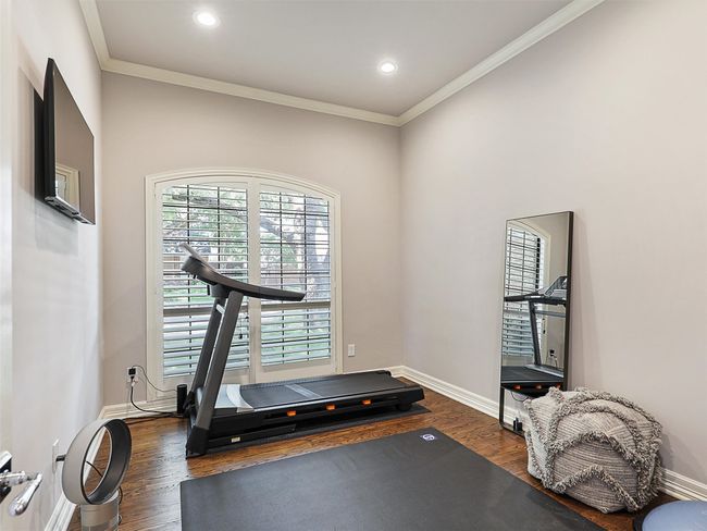 Exercise room featuring dark wood-style flooring, ornamental molding, and recessed lighting | Image 24