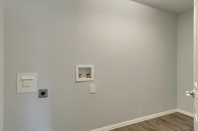 Laundry area featuring hookup for an electric dryer, dark wood-type flooring, and hookup for a washing machine | Image 19