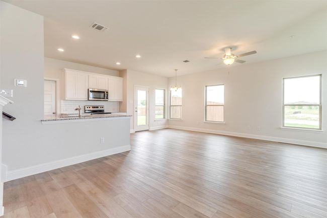 Unfurnished living room featuring ceiling fan and light hardwood / wood-style flooring | Image 6