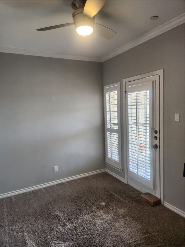 Second bedroom with balcony, featuring carpet, ornamental molding, ceiling fan, and baseboards | Image 12