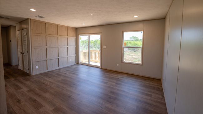 Unfurnished room with dark wood-style floors, recessed lighting, and a decorative wall | Image 34