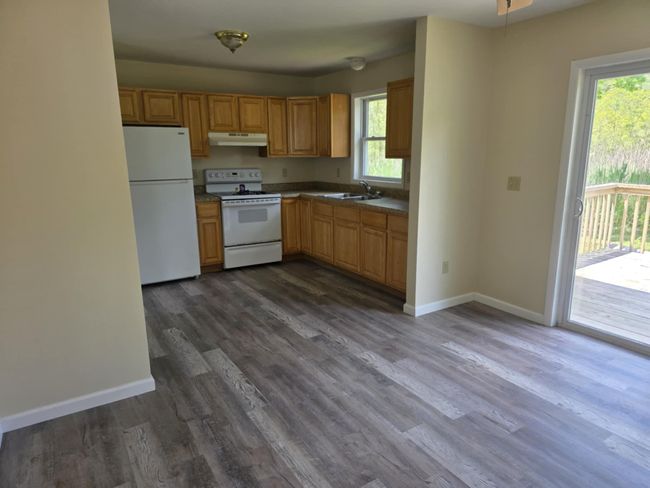 Kitchen featuring white appliances, dark wood-style flooring, and under cabinet range hood | Image 11