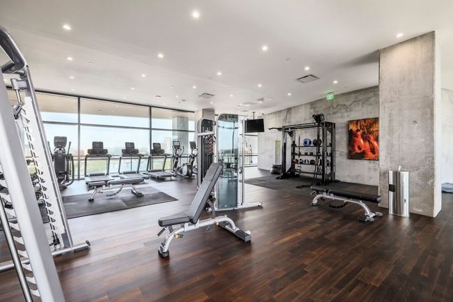 Workout area with wood finished floors, floor to ceiling windows, and recessed lighting | Image 28