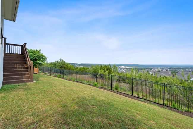 Stairs off the porch lead down to a perfectly sized fenced-in backyard. | Image 30