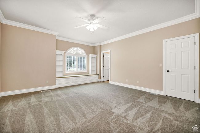Unfurnished room with ceiling fan, crown molding, carpet flooring, and baseboards | Image 21