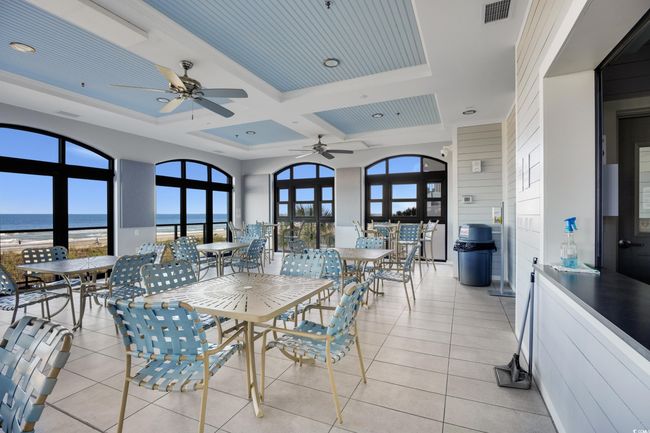 Dining room featuring ceiling fan, light tile patterned floors, coffered ceiling, and a water view | Image 30