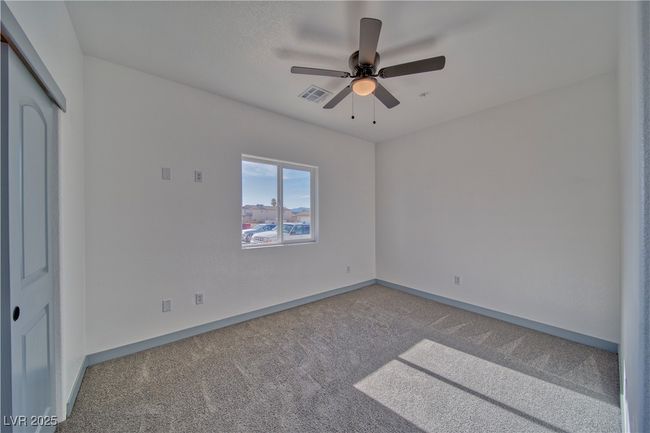 Guest bedroom 2 featuring a spacious layout, plush carpet, and an Onyx ceiling fan with light for added comfort. | Image 12