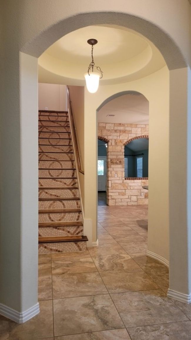 Hallway with stairs, baseboards, and arched walkways | Image 5
