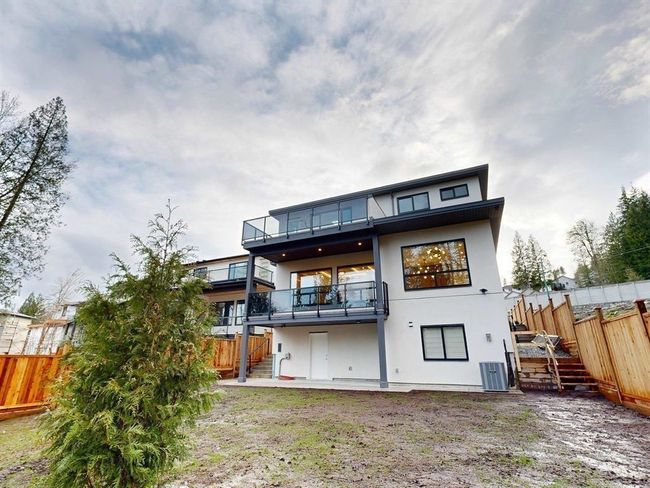 Rear view of house with a balcony, stairs, a fenced backyard, stucco siding, and a patio | Image 27