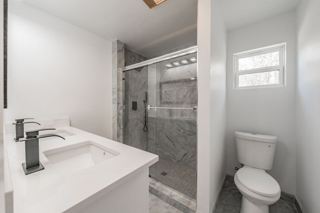 Full bath with marble finish floors, a marble finish shower, toilet, and double vanity | Image 18