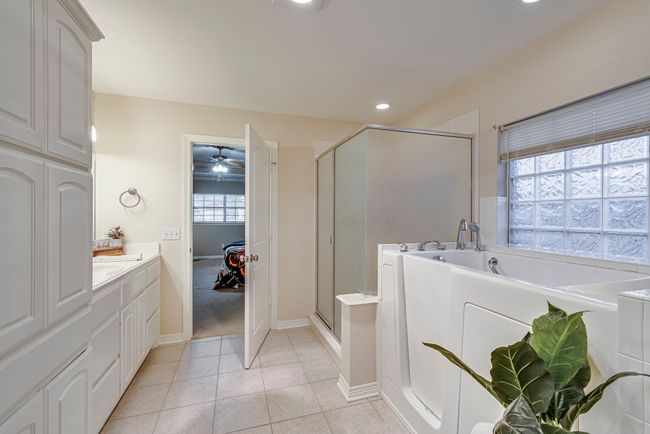 Bathroom featuring tile patterned floors, vanity, ceiling fan, and a shower with door | Image 5