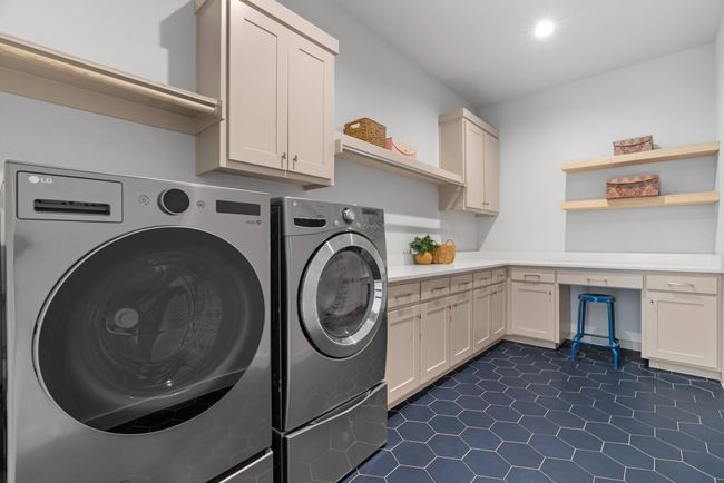 Laundry room with cabinet space, washer and dryer, and dark tile patterned flooring | Image 20