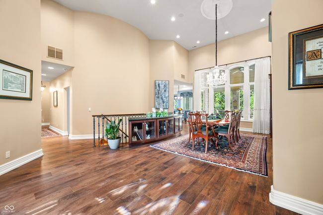 dining area with visible vents, baseboards, an inviting chandelier, wood finished floors, and a high ceiling | Image 14