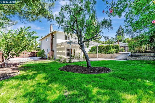 Lower lawn area off of family room with steps leading up to the pool. | Image 31