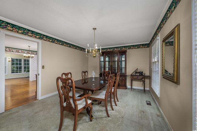 Carpeted dining space featuring a chandelier and crown molding | Image 11