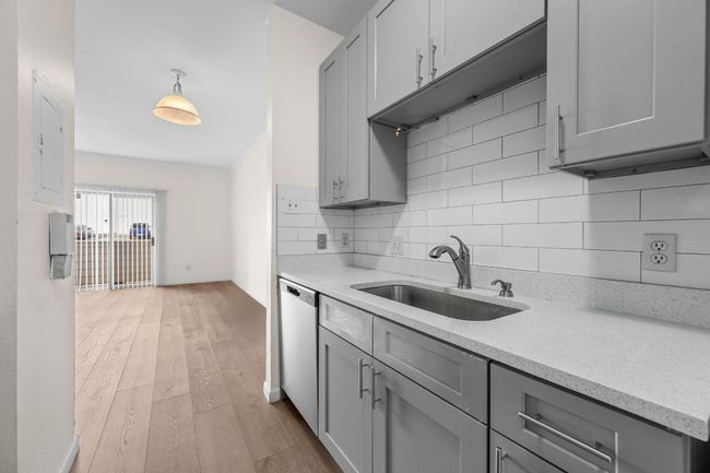 Kitchen with a sink, gray cabinetry, stainless steel dishwasher, and backsplash | Image 7