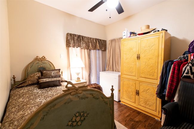 Bedroom featuring dark wood-type flooring, refrigerator, and a ceiling fan | Image 8