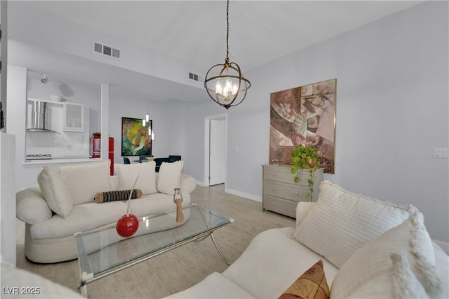 Living area featuring a chandelier and wood finished floors | Image 8