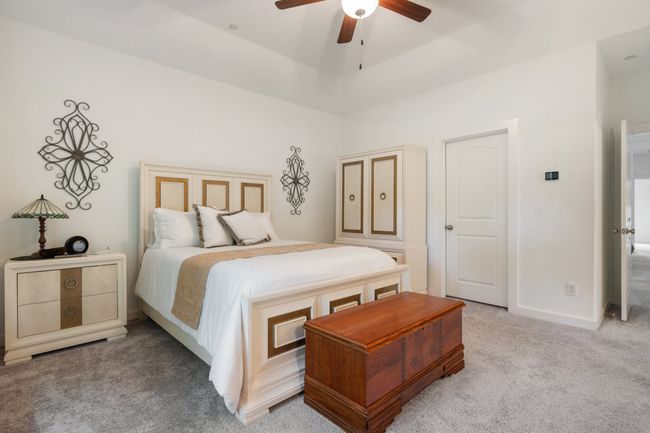 Bedroom with light carpet, a ceiling fan, and baseboards | Image 16
