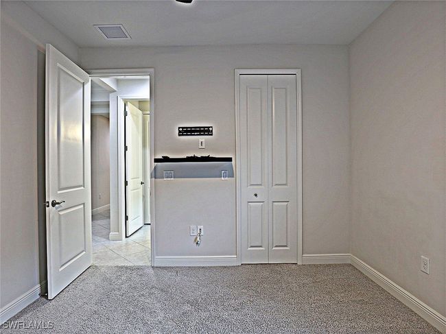 Unfurnished bedroom featuring light colored carpet, baseboards, and a closet | Image 19