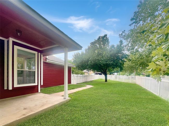 Fenced backyard with a patio | Image 35