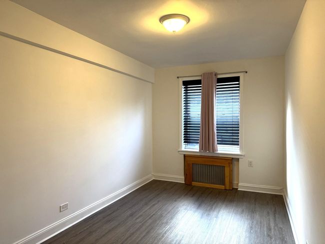Unfurnished room featuring radiator and dark wood-type flooring | Image 16