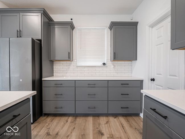 kitchen featuring gray cabinets, freestanding refrigerator, and decorative backsplash | Image 22