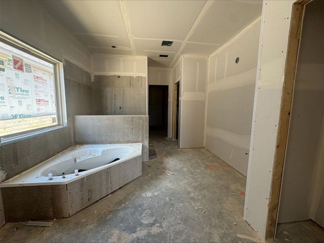 Full bath featuring a whirlpool tub and concrete floors | Image 6